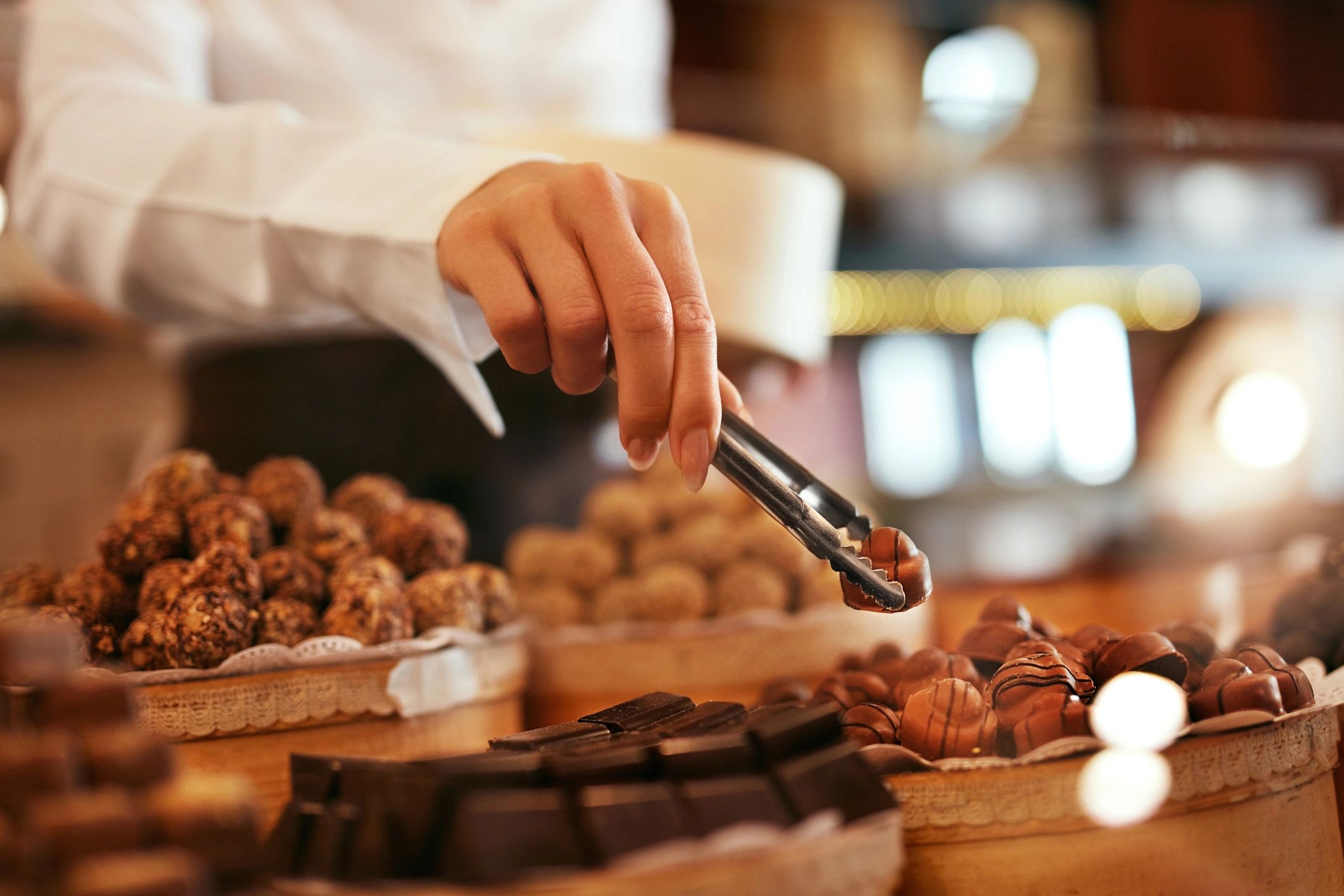 Chocolate Candies In Confectionery Store. Closeup Of Female